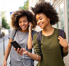 Two young women listening to music on mobile phone